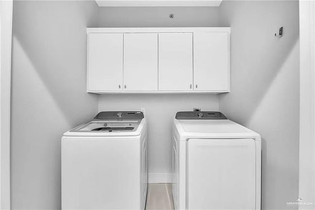 Laundry area featuring cabinet space and washing machine and clothes dryer | Image 12