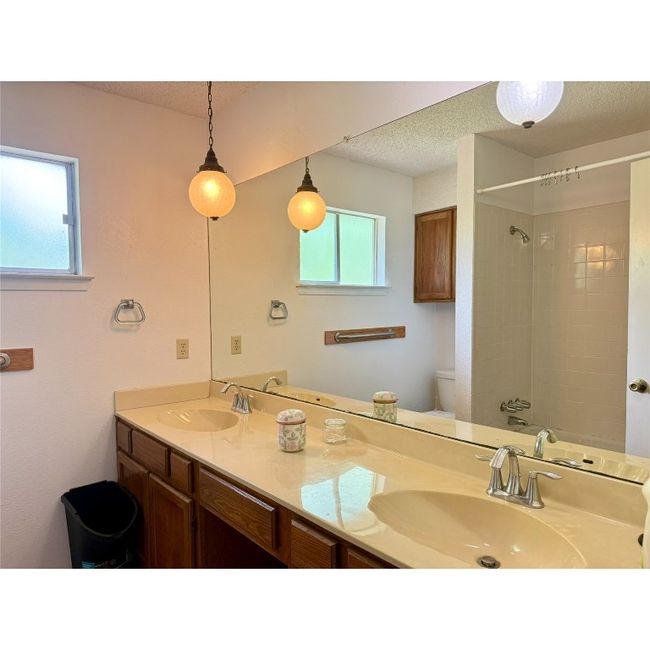 Bathroom with vanity and a tub with shower | Image 23
