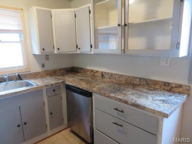 Kitchen featuring dishwasher, light tile patterned floors, light stone counters, and sink | Image 12