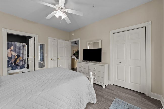 Bedroom with dark wood-type flooring, baseboards, and a ceiling fan | Image 9