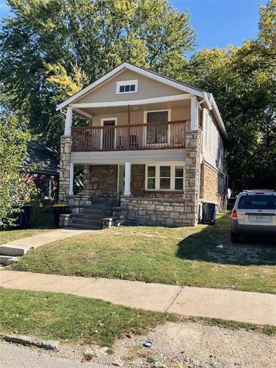 View of front facade featuring a front yard and a balcony | Image 1