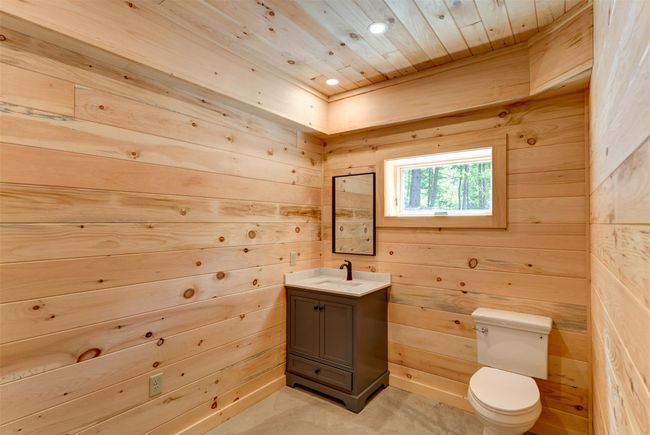 Bathroom with wood walls, vanity, toilet, wooden ceiling, and recessed lighting | Image 36