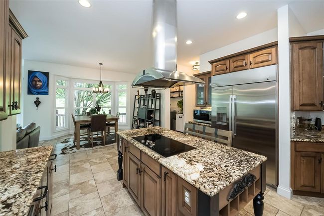 Kitchen with a kitchen island, appliances with stainless steel finishes, island exhaust hood, and light stone counters | Image 20