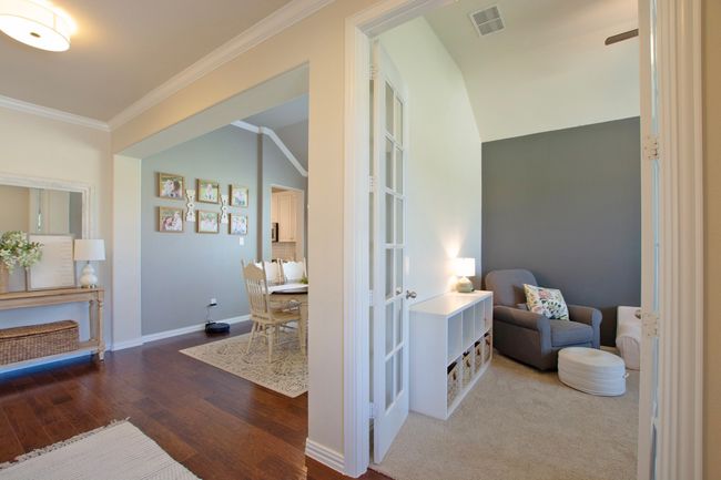 Hallway featuring visible vents, crown molding, wood finished floors, baseboards, and french doors | Image 6
