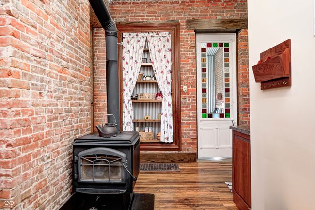 interior details with wood finished floors and a wood stove | Image 26