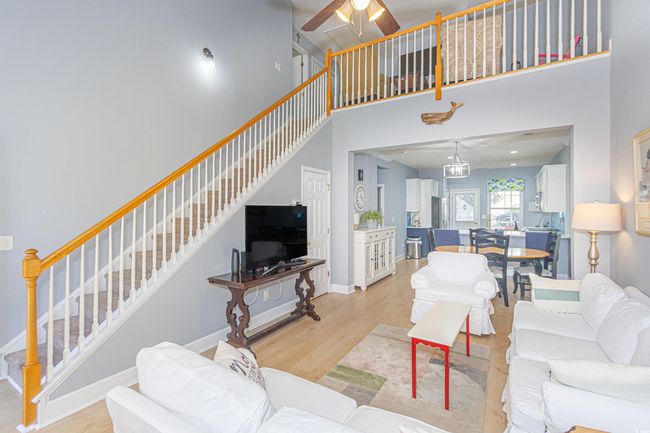 Living room featuring light hardwood / wood-style floors, ceiling fan, and a high ceiling | Image 4