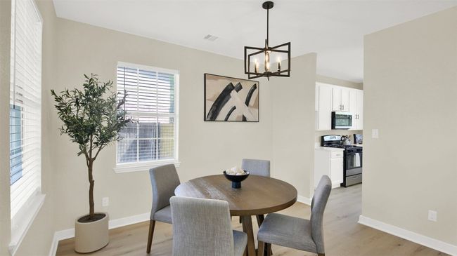 Dining area featuring light wood-type flooring, visible vents, baseboards, and a notable chandelier | Image 4