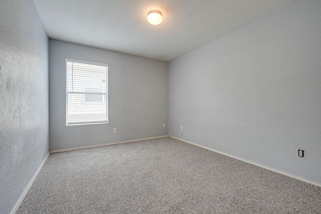 Carpeted empty room featuring baseboards and a textured wall | Image 19