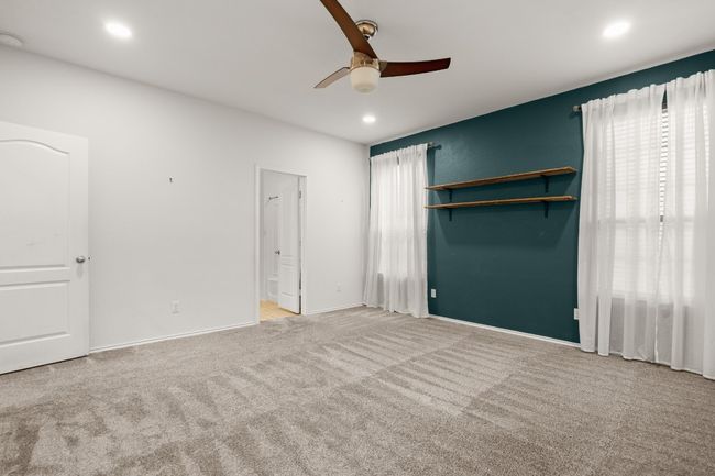 Unfurnished bedroom featuring baseboards, recessed lighting, a ceiling fan, carpet, and ensuite bath | Image 10
