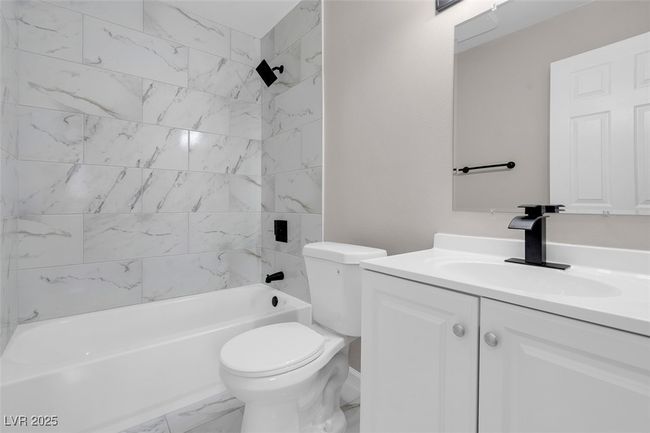 Full bathroom featuring marble finish floor, toilet, vanity, and bathing tub / shower combination | Image 27