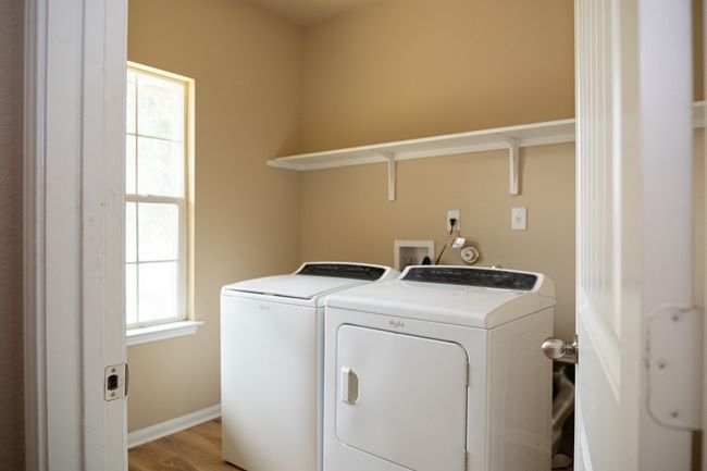 Laundry area with washing machine and clothes dryer, light wood-style flooring, and baseboards | Image 25