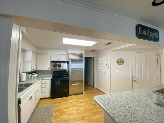 Kitchen featuring stainless steel appliances, white cabinetry | Image 10
