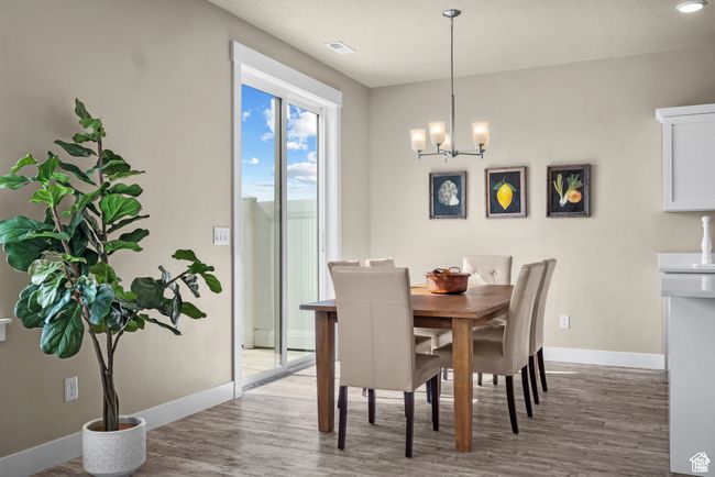 Dining space with baseboards, a chandelier, and wood finished floors | Image 9