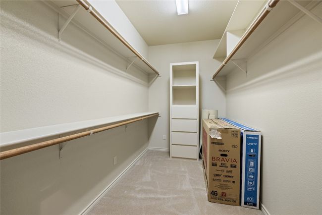 Walk in closet featuring light colored carpet | Image 17