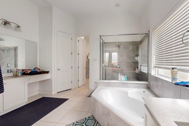 Full bath featuring a shower stall, tile patterned floors, vanity, and a garden tub | Image 17