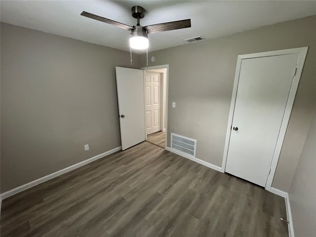Unfurnished bedroom with wood finished floors, baseboards, and a ceiling fan | Image 17