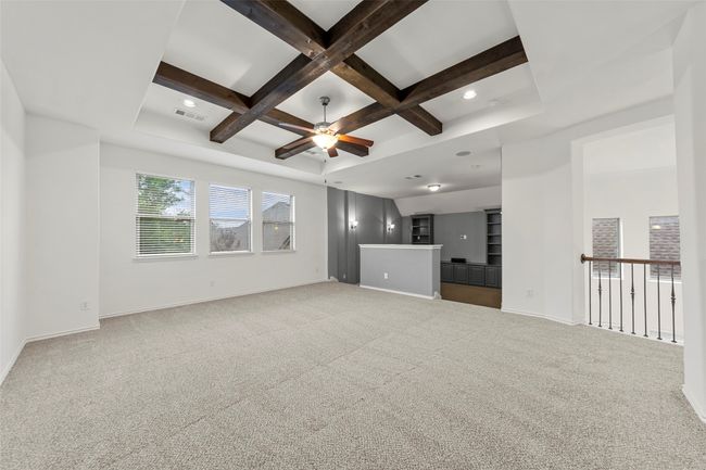 Unfurnished living room with visible vents, a ceiling fan, coffered ceiling, and carpet | Image 22