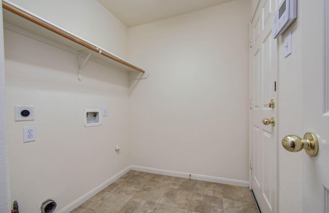 The utility room is located off the foyer to the garage. | Image 25