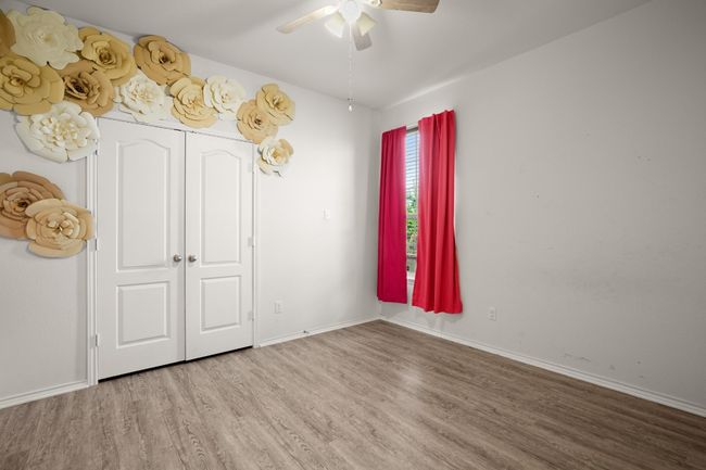 Unfurnished bedroom with baseboards, ceiling fan, and wood finished floors | Image 5