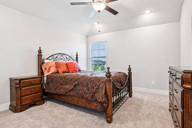 Bedroom featuring light colored carpet, lofted ceiling, a ceiling fan, and recessed lighting | Image 22