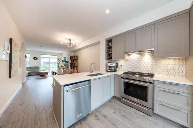 Kitchen featuring stainless steel appliances, a sink, gray cabinets, a peninsula, and recessed lighting | Image 8
