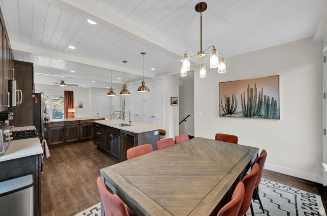 Dining room with dark wood-type flooring, baseboards, recessed lighting, wood ceiling with exposed beams, and ceiling fan | Image 18