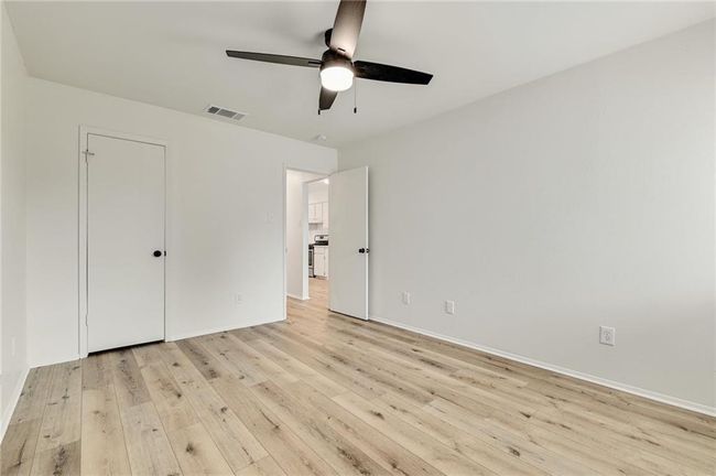 Unfurnished bedroom with light wood finished floors, baseboards, and ceiling fan | Image 9