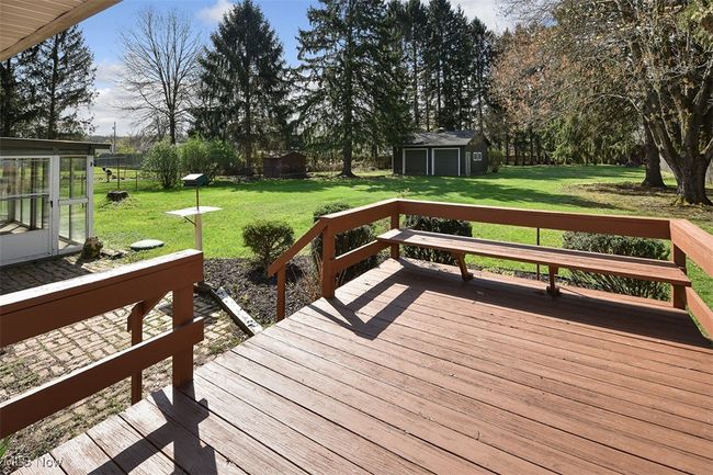 Wooden terrace with a lawn and an outdoor structure | Image 9