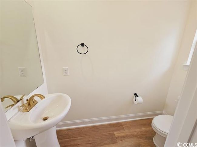 Bathroom featuring baseboards, a sink, toilet, and wood finished floors | Image 33