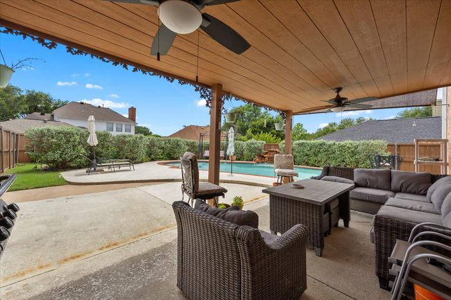 Fenced backyard featuring ceiling fan, outdoor lounge area, and a patio | Image 31