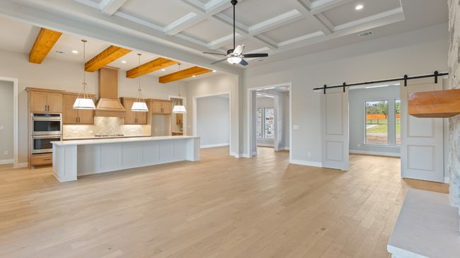 Kitchen featuring open floor plan, beam ceiling, a ceiling fan, decorative backsplash, and decorative light fixtures | Image 20