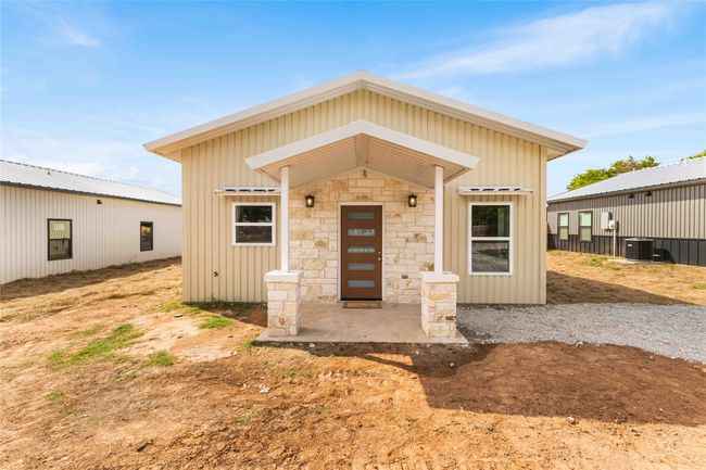 View of front of property featuring central AC, stone siding, and board and batten siding | Image 5