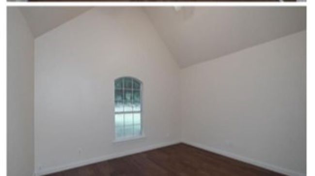 Spare room featuring dark wood finished floors and high vaulted ceiling | Image 18