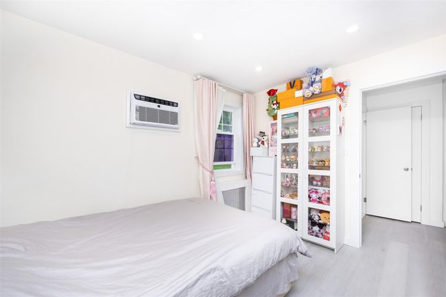 Bedroom with an AC wall unit, wood finished floors, and recessed lighting | Image 16
