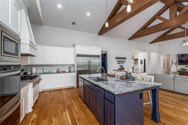 Kitchen featuring high vaulted ceiling, a sink, open floor plan, a breakfast bar area, and built in appliances | Image 12