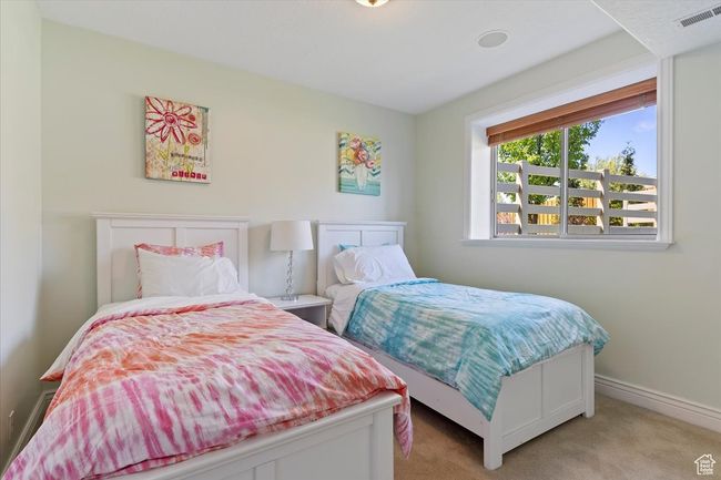 Bedroom featuring baseboards, light colored carpet, and visible vents | Image 44