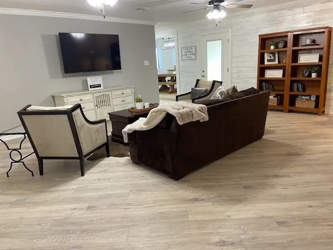 Living room with light hardwood / wood-style floors, ceiling fan, and crown molding | Image 4