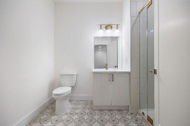 Full bath with a stall shower, toilet, baseboards, and vanity | Image 27
