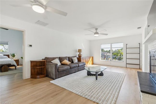 Living area featuring visible vents, a ceiling fan, and light wood-style flooring | Image 18