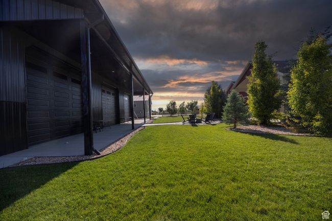 View of grassy yard with a pool house and a patio area | Image 89