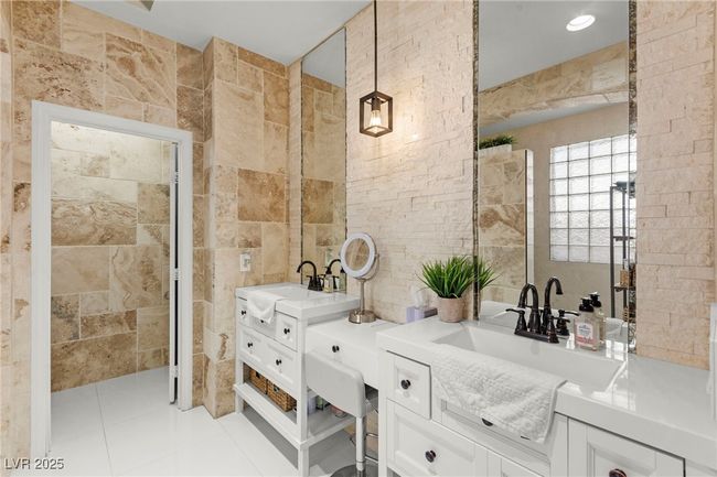 Full bathroom featuring tile walls, two vanities, and tile patterned floors | Image 26