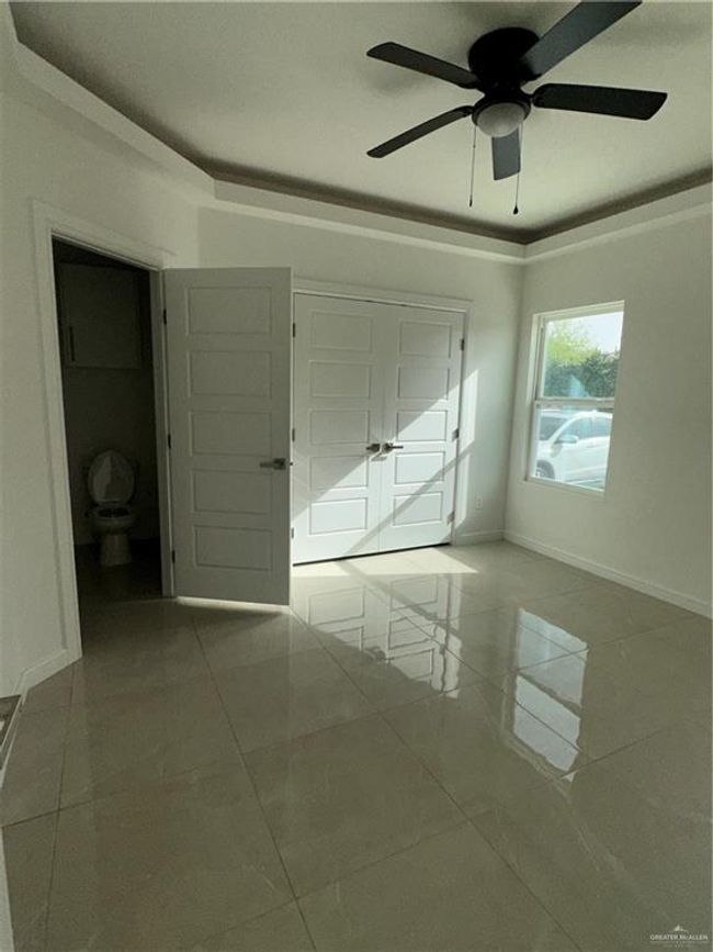 Unfurnished bedroom with baseboards, marble finish floor, and ceiling fan | Image 5