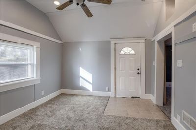 Carpeted foyer entrance featuring ceiling fan and vaulted ceiling | Image 3