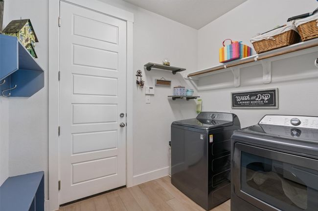 Washroom with washing machine and clothes dryer, light wood-style flooring, and baseboards | Image 26
