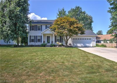 Colonial-style house featuring a garage and a front yard | Image 2