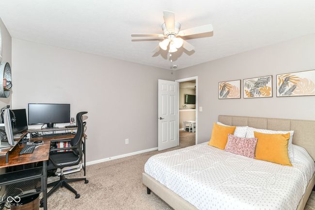 carpeted bedroom with an office area, baseboards, and ceiling fan | Image 24