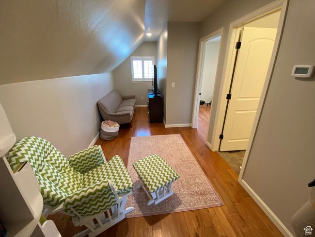 Bedroom with light wood-style floors, vaulted ceiling, and baseboards | Image 19