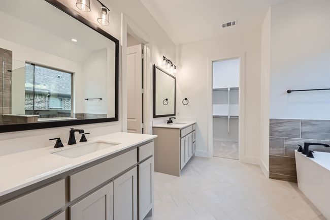 Bathroom with two vanities, a freestanding tub, visible vents, and a sink | Image 15