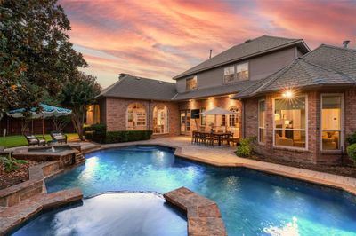 Enjoy this gorgeous oasis complete with a lit up pool, an in ground hot tub, and patio. | Image 2