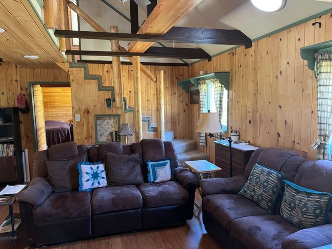 Living area featuring wood finished floors, wooden walls, and beamed ceiling | Image 13
